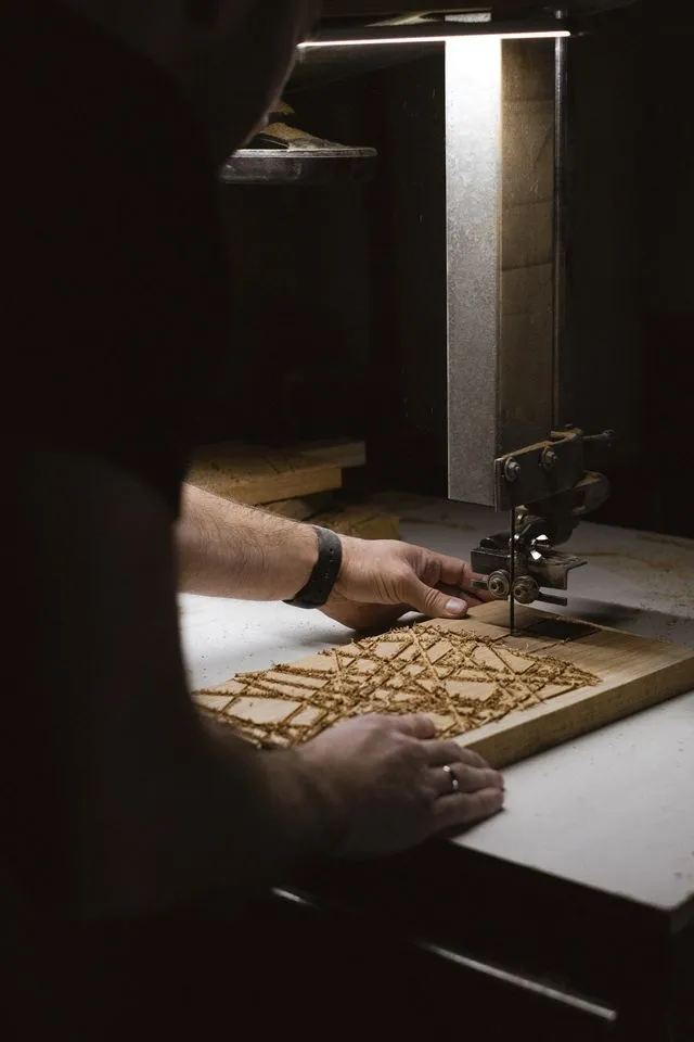 Craftsperson cutting a geometric pattern into a timber panel