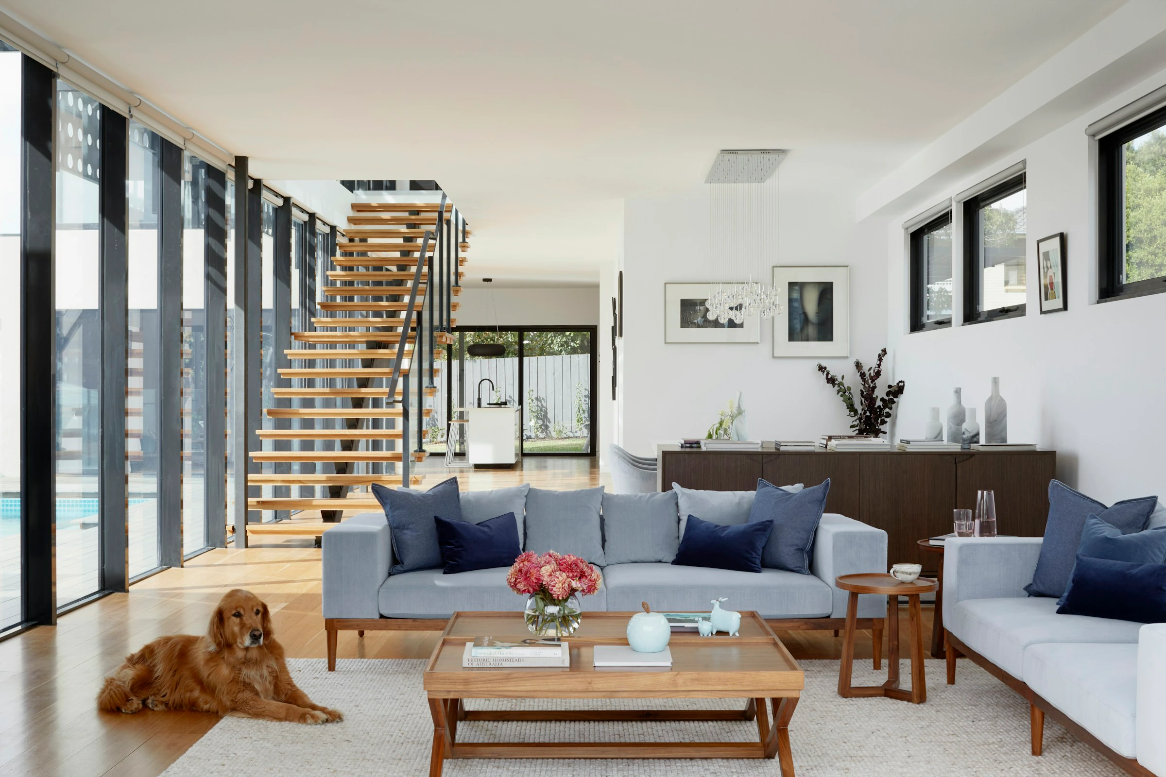 Complete residential living room with an open timber stair, art, furniture and objects