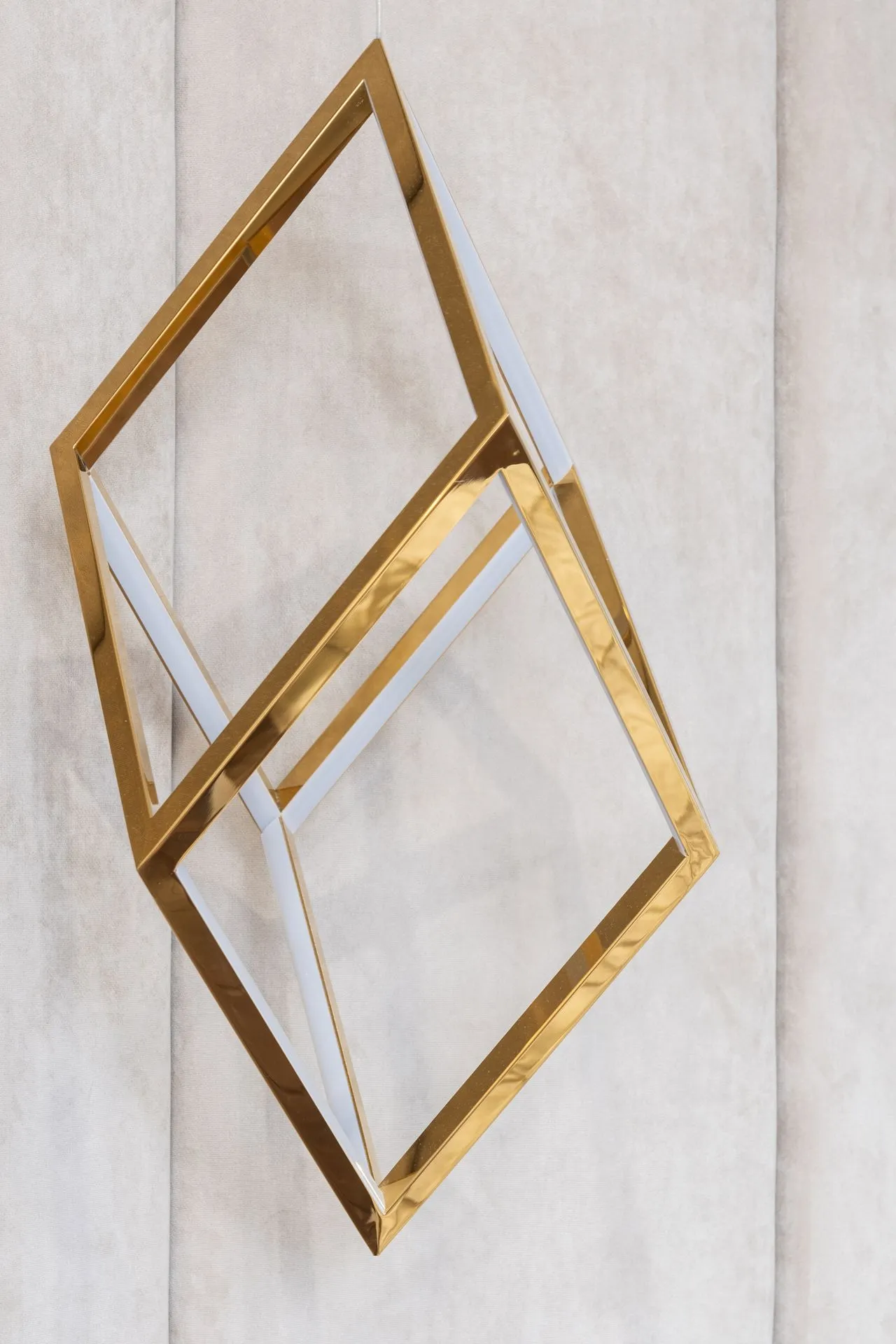 Geometric brass sculpture against pale stone