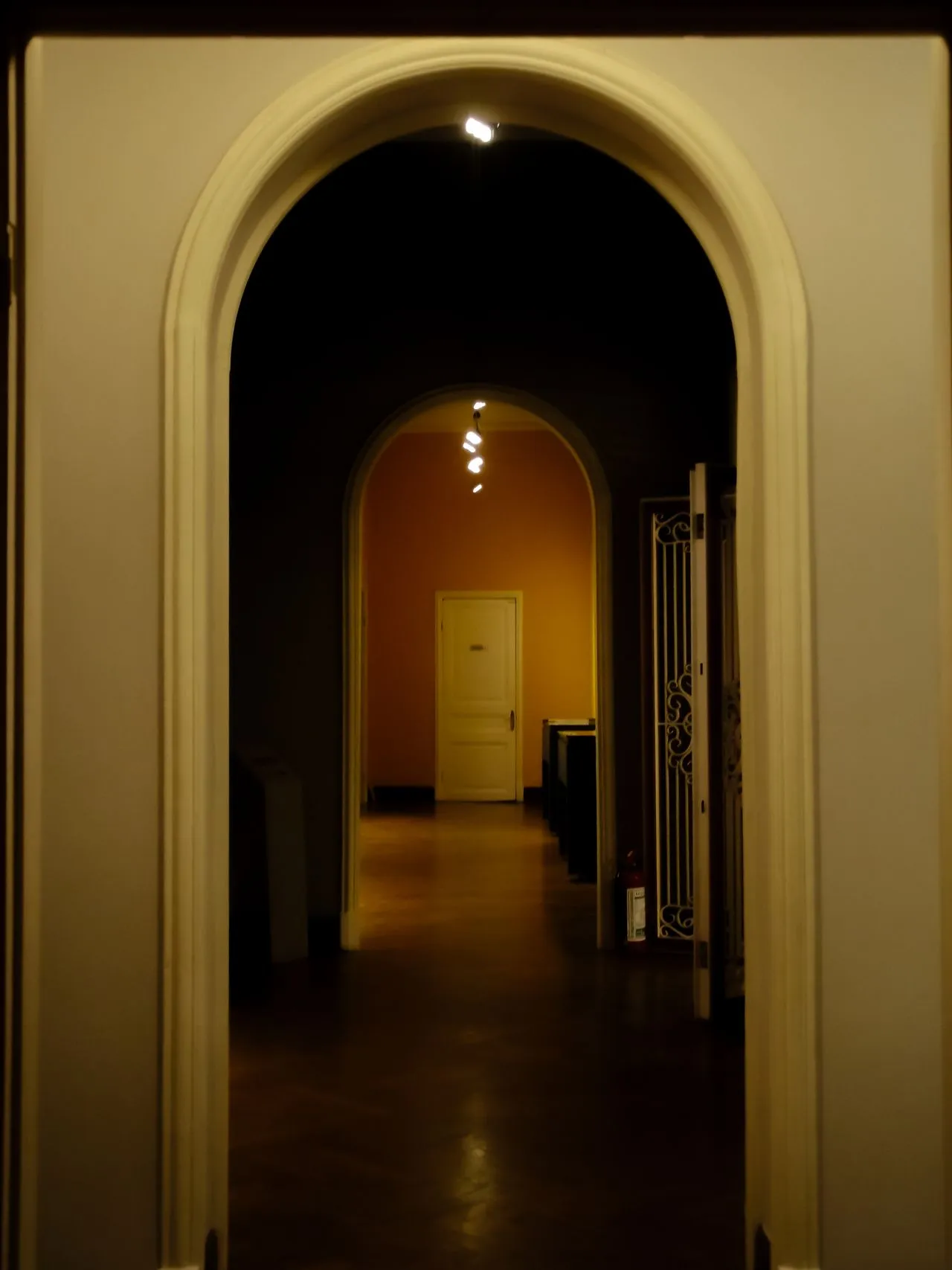 Arched hallway illuminated by a warm pool of light