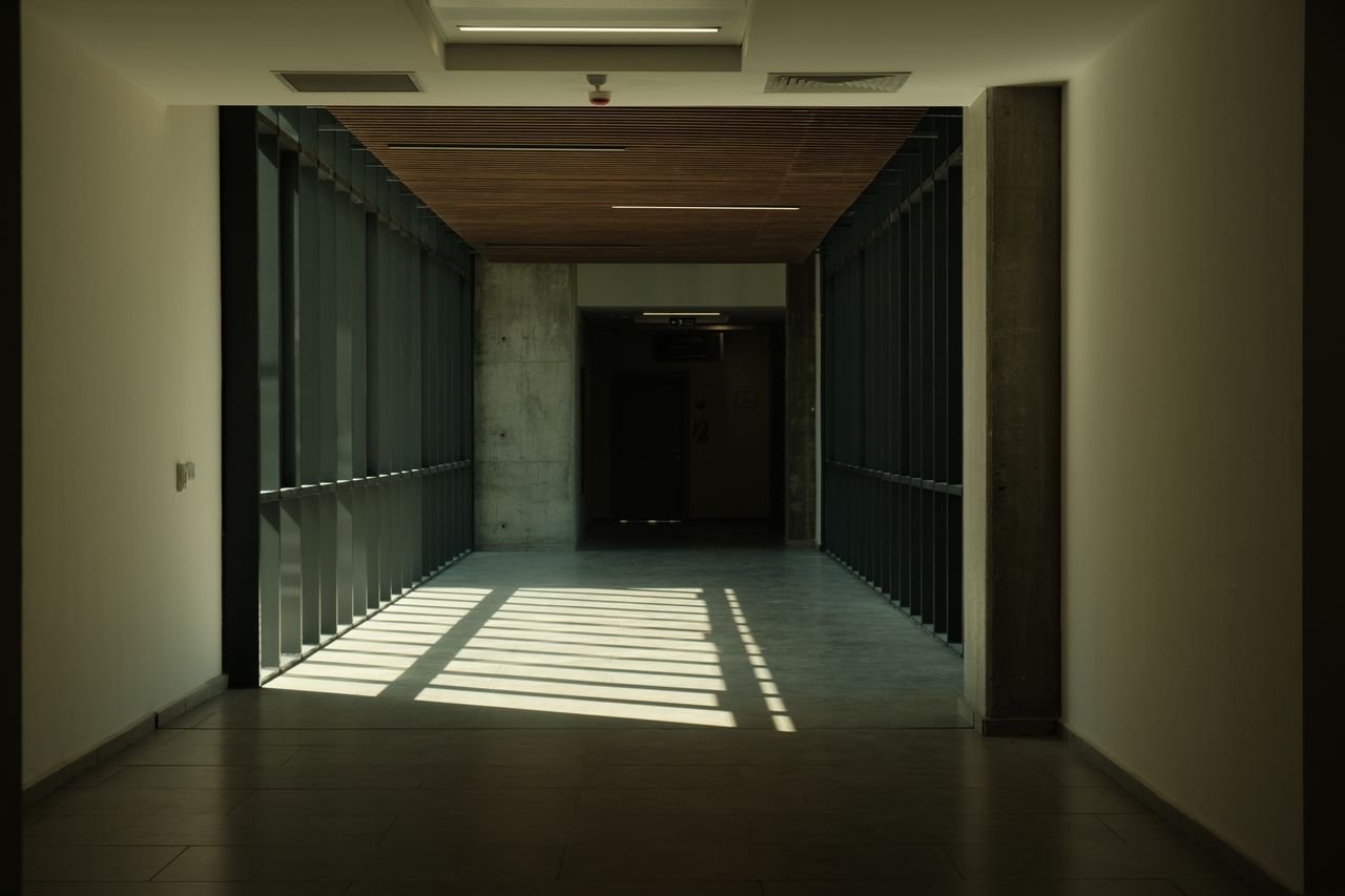 Quiet corridor receding toward a dark doorway