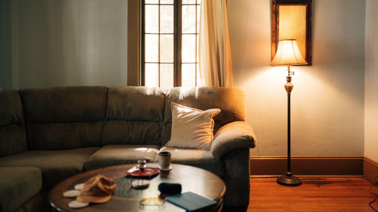 Sofa and table illuminated by a low floor lamp