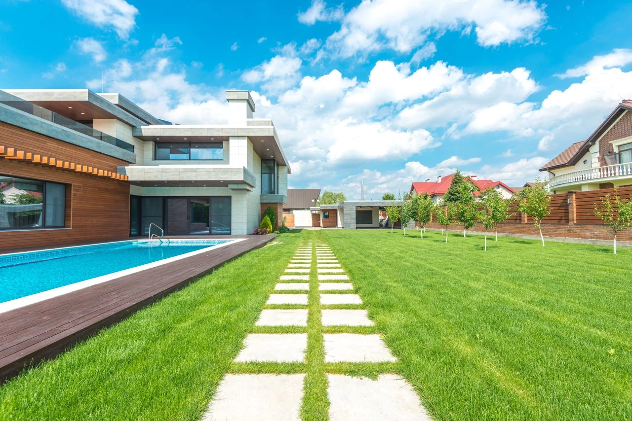 Modern courtyard house opening onto a lawn and swimming pool