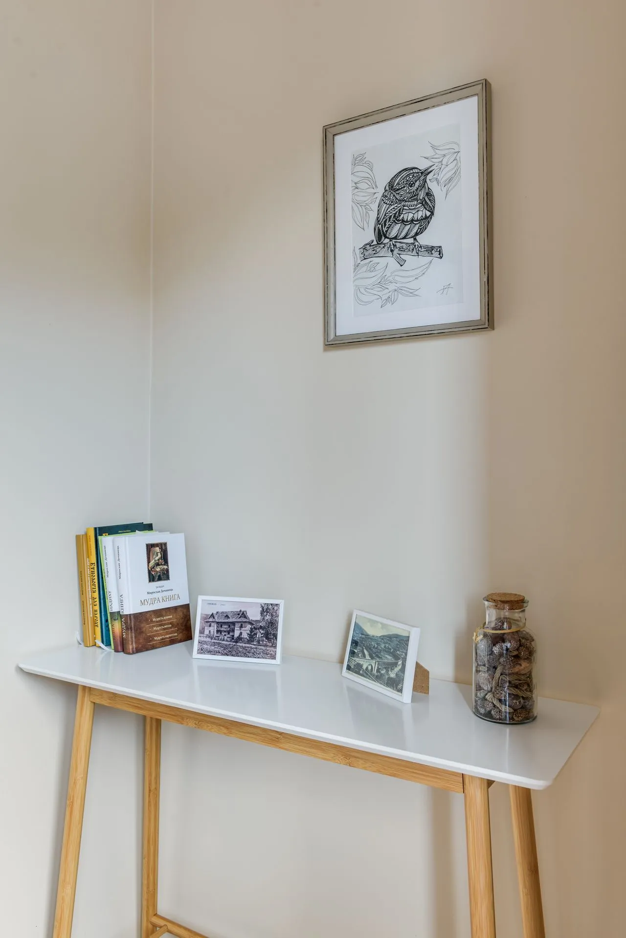 Small framed drawing and collected objects on a narrow table