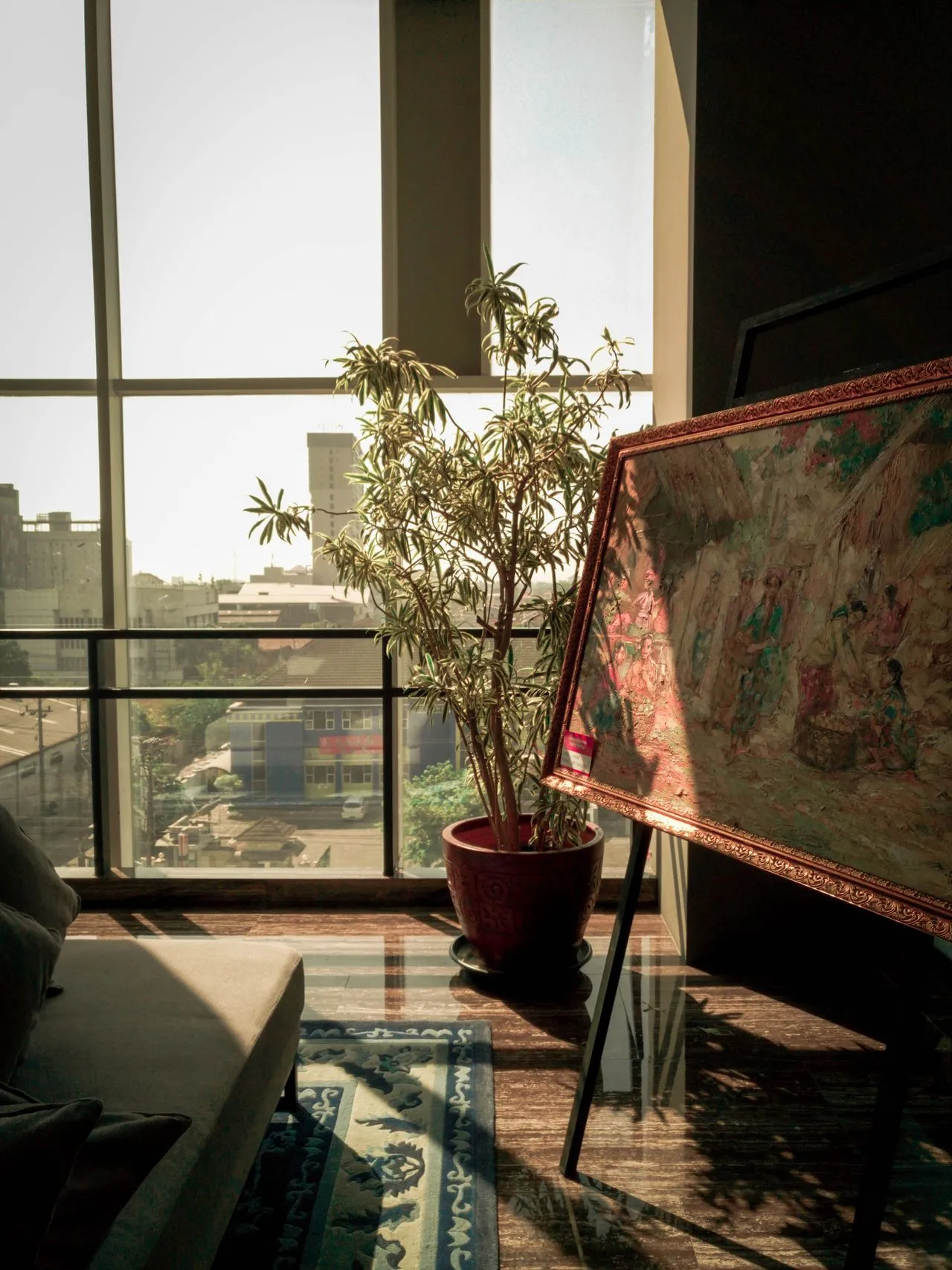 Framed artwork catching daylight beside a city window