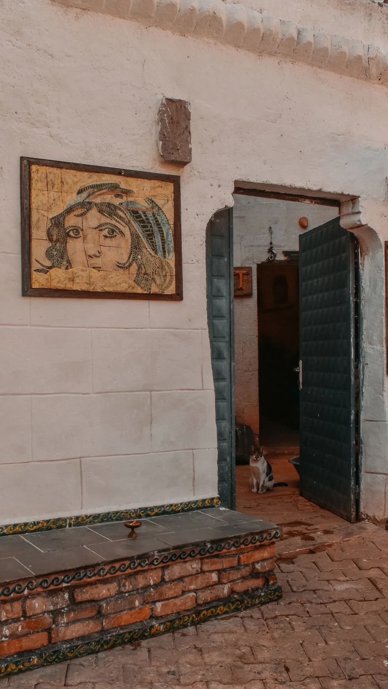 Portrait artwork beside a dark doorway