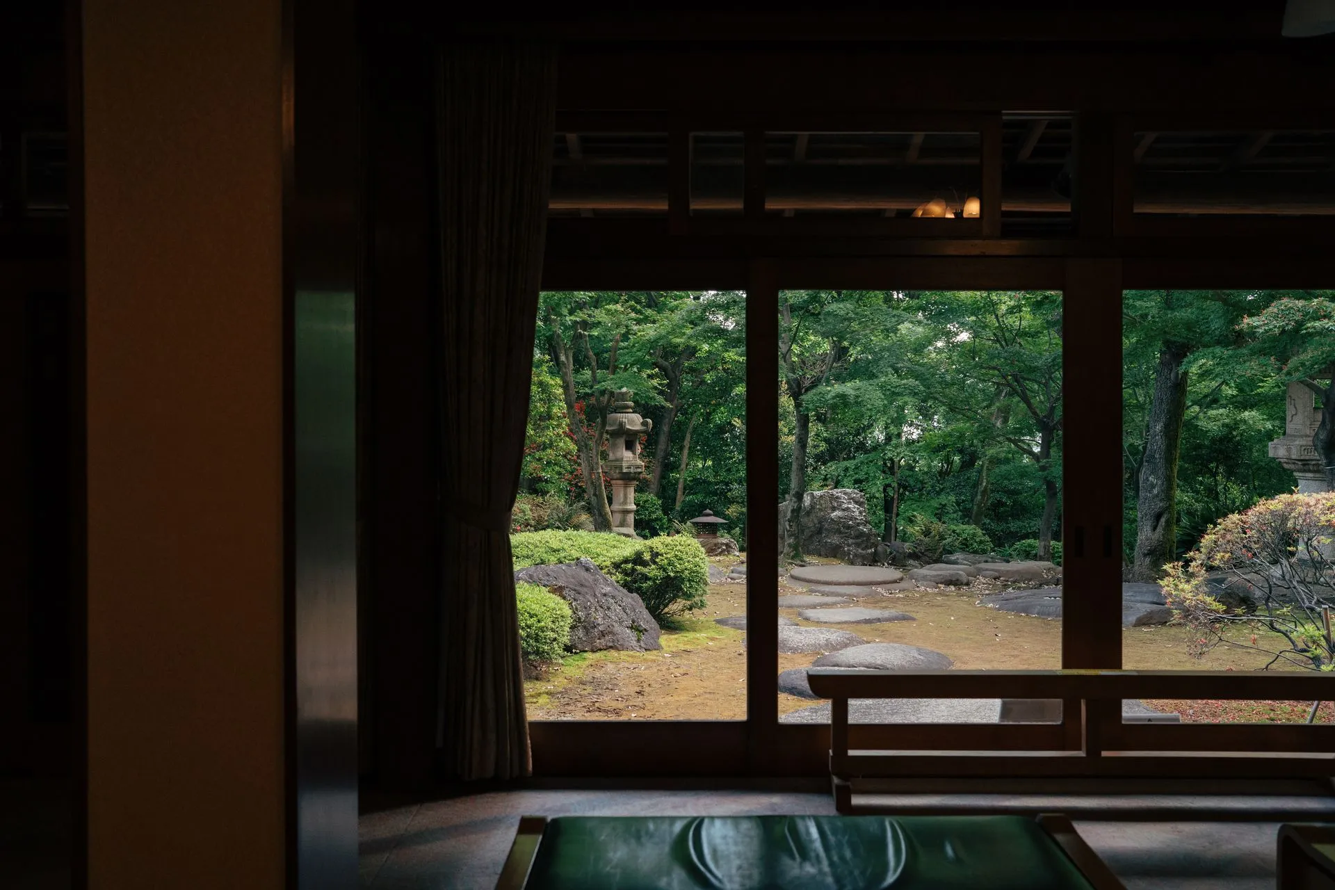 Framed view into a mature garden from a dark interior